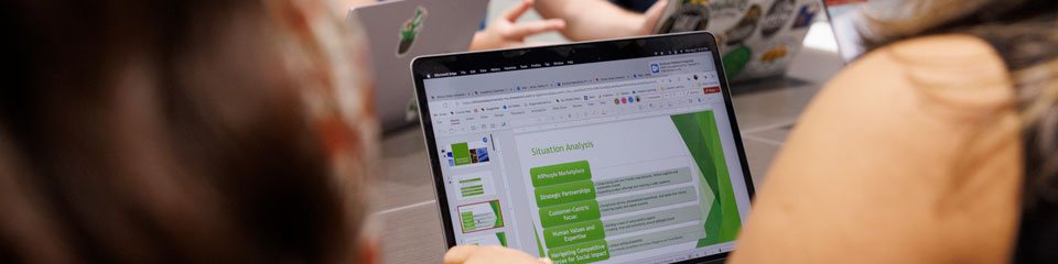 Student reviewing a powerpoint on her laptop.