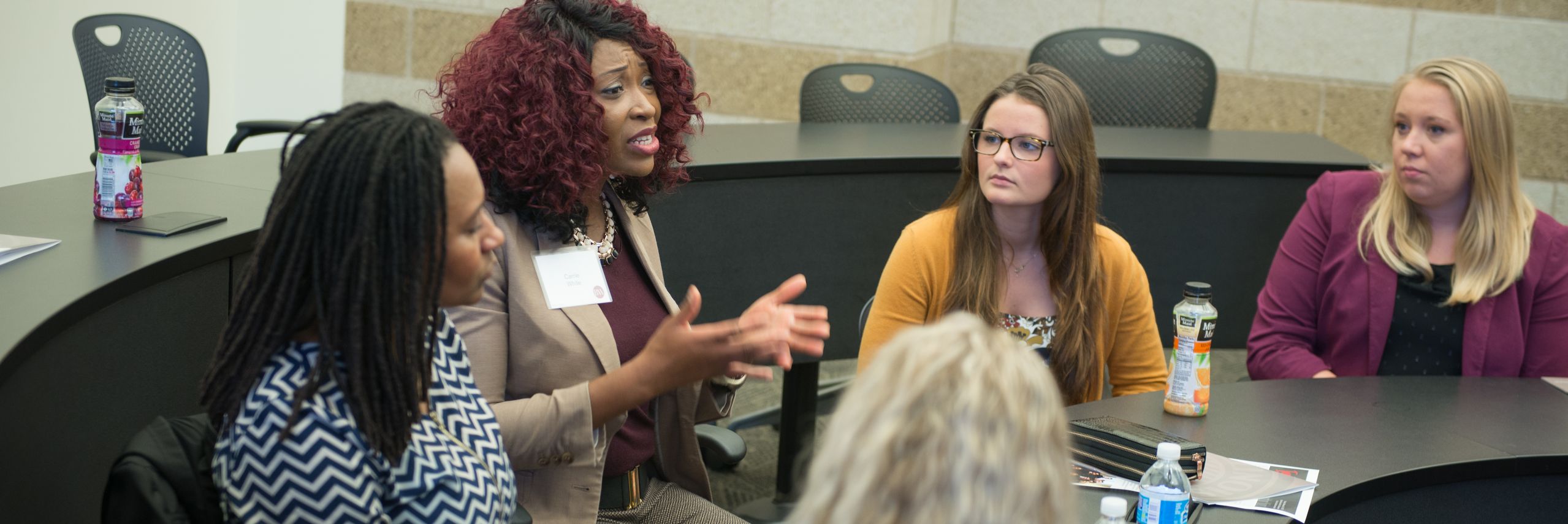 Business women and students involved in a discussion